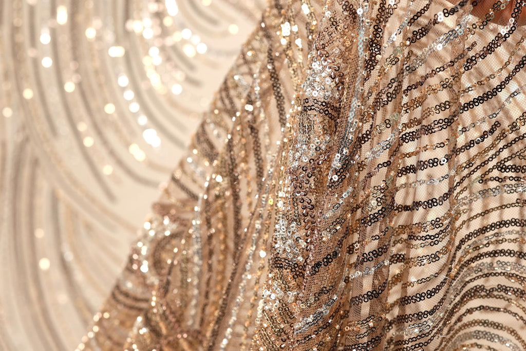 The image is a close-up of a sequined fabric, showcasing its intricate and shimmering patterns.