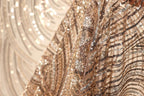 The image is a close-up of a sequined fabric, showcasing its intricate and shimmering patterns.