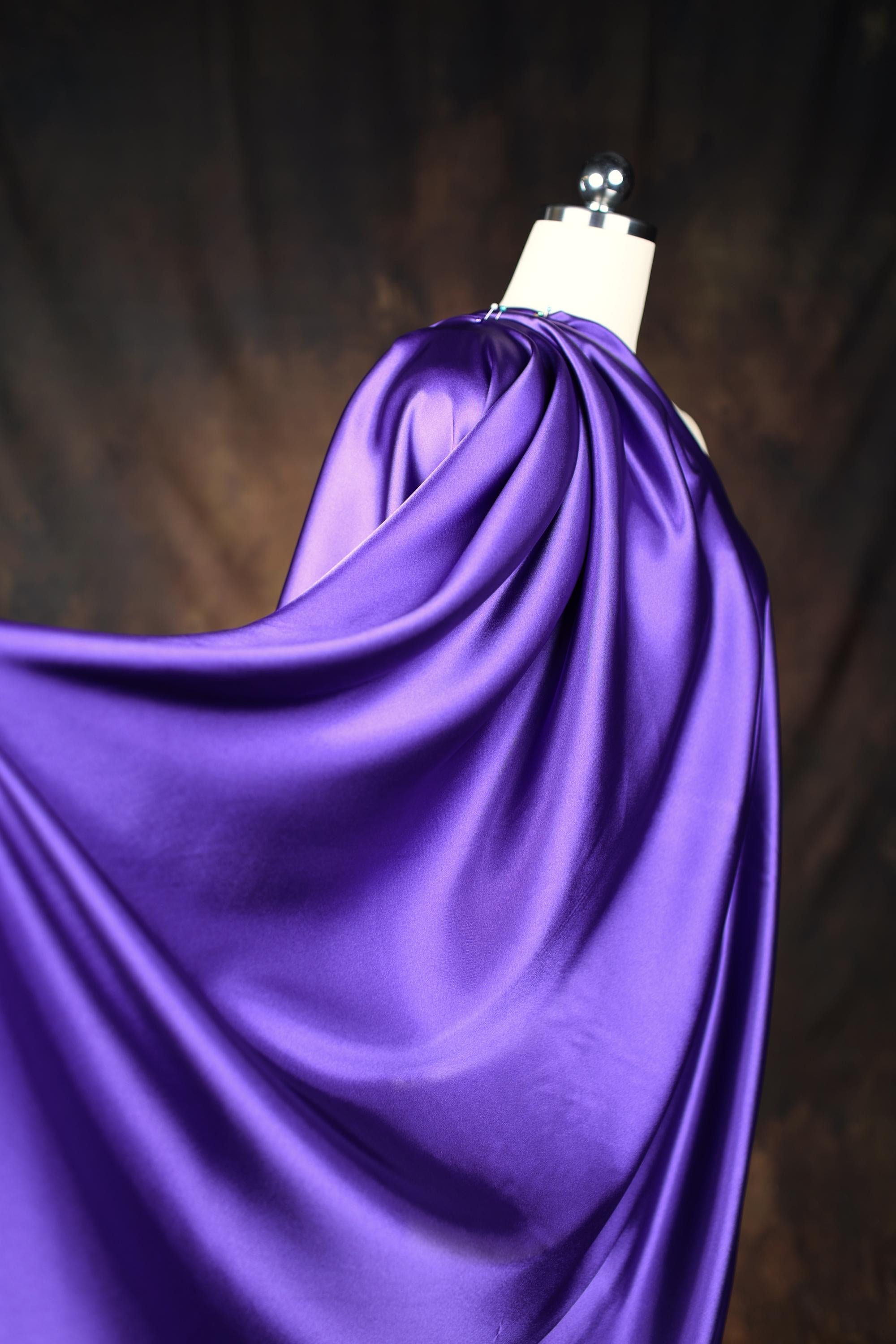 a dress on a mannequin with a purple cloth draped over it