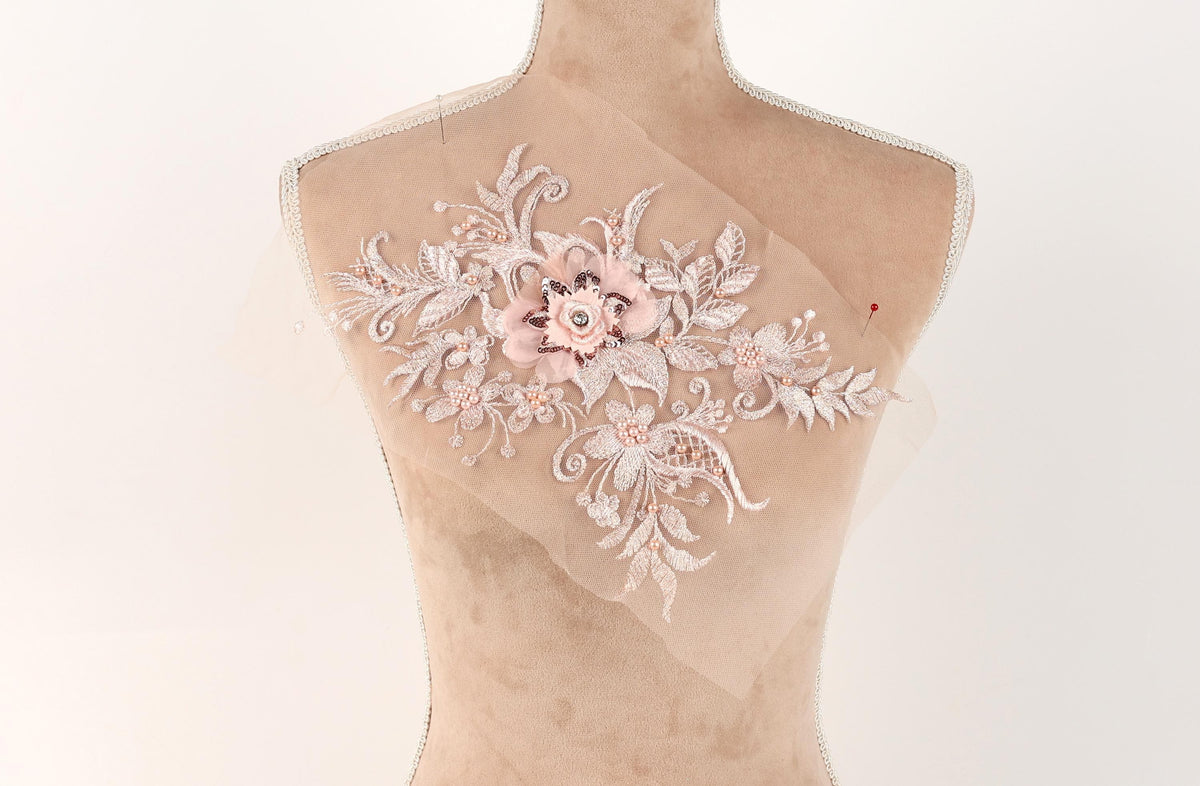 A mannequin with a delicate, floral embroidered patch on its bust.