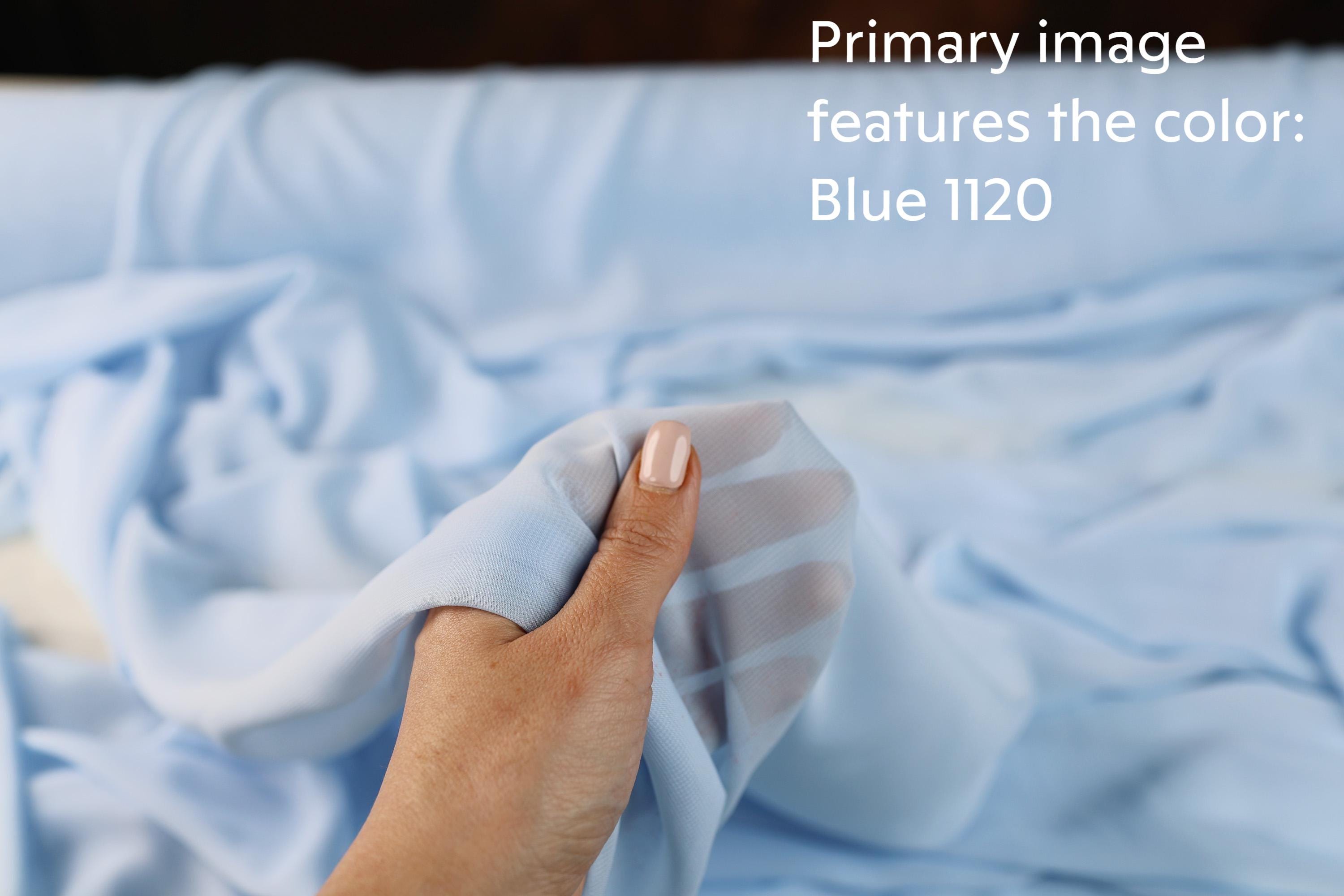 A hand holding a piece of blue fabric, with the text &quot;Primary image features the color Blue 1120&quot; overlaid on the image.