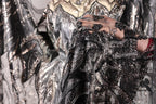 A close-up view of a black and silver sequined fabric, with intricate patterns and designs.