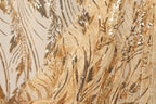 The image is a close-up view of a fabric with a gold and black sequined pattern, featuring a delicate and intricate design.