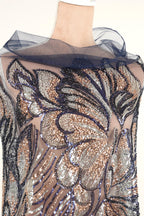 a mannequin wearing a dress with a floral pattern and sequin details.