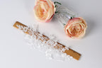 a lace piece, a wooden ruler, and two pink roses on a white background.