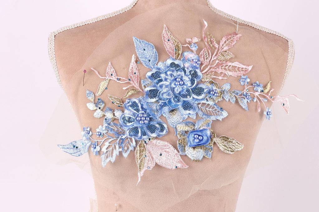 A mannequin with a delicate floral embroidered on its back, featuring blue and pink flowers and leaves.
