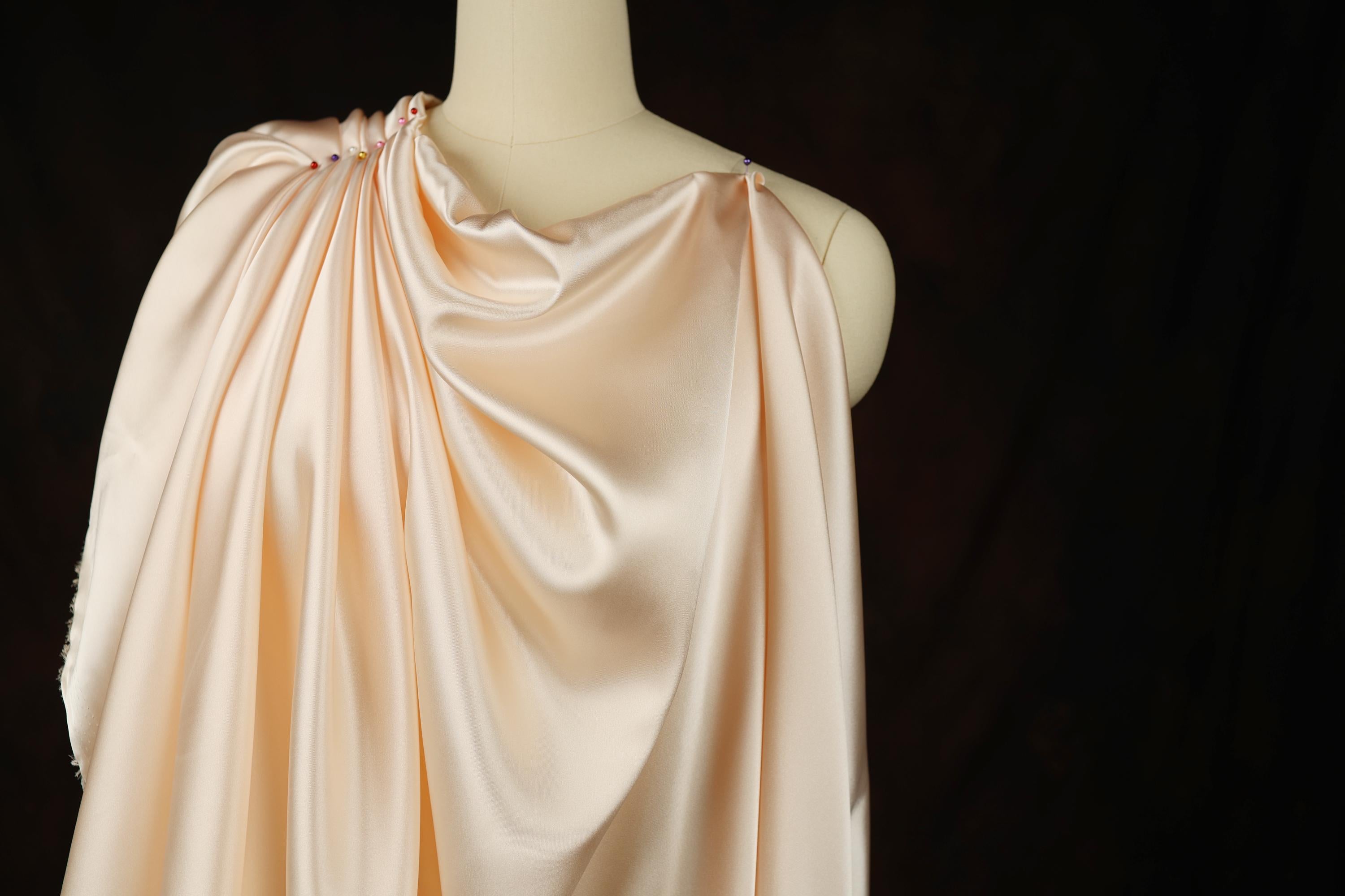 a mannequin wearing a pink dress on a black background