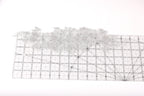 a piece of fabric with a floral pattern, placed on a ruler for size reference.