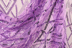 a close-up view of a fabric with a purple and black sequin pattern, creating a visually striking and intricate design.