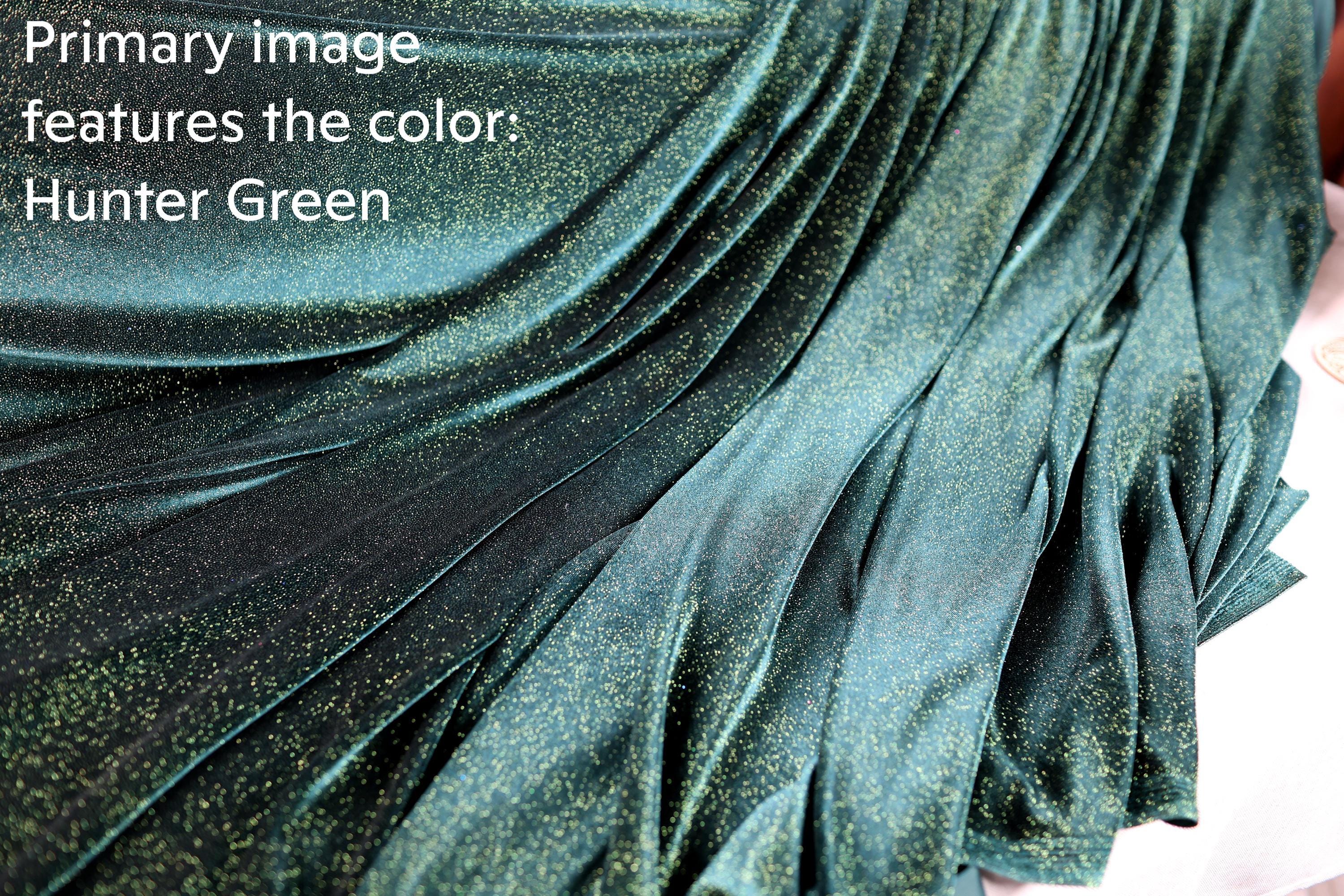 a close-up view of a shiny, green fabric with a glittery texture, resembling a piece of jewelry or a decorative material.