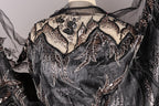 a close-up view of a black and silver sequined dress with intricate embroidery and beading details.