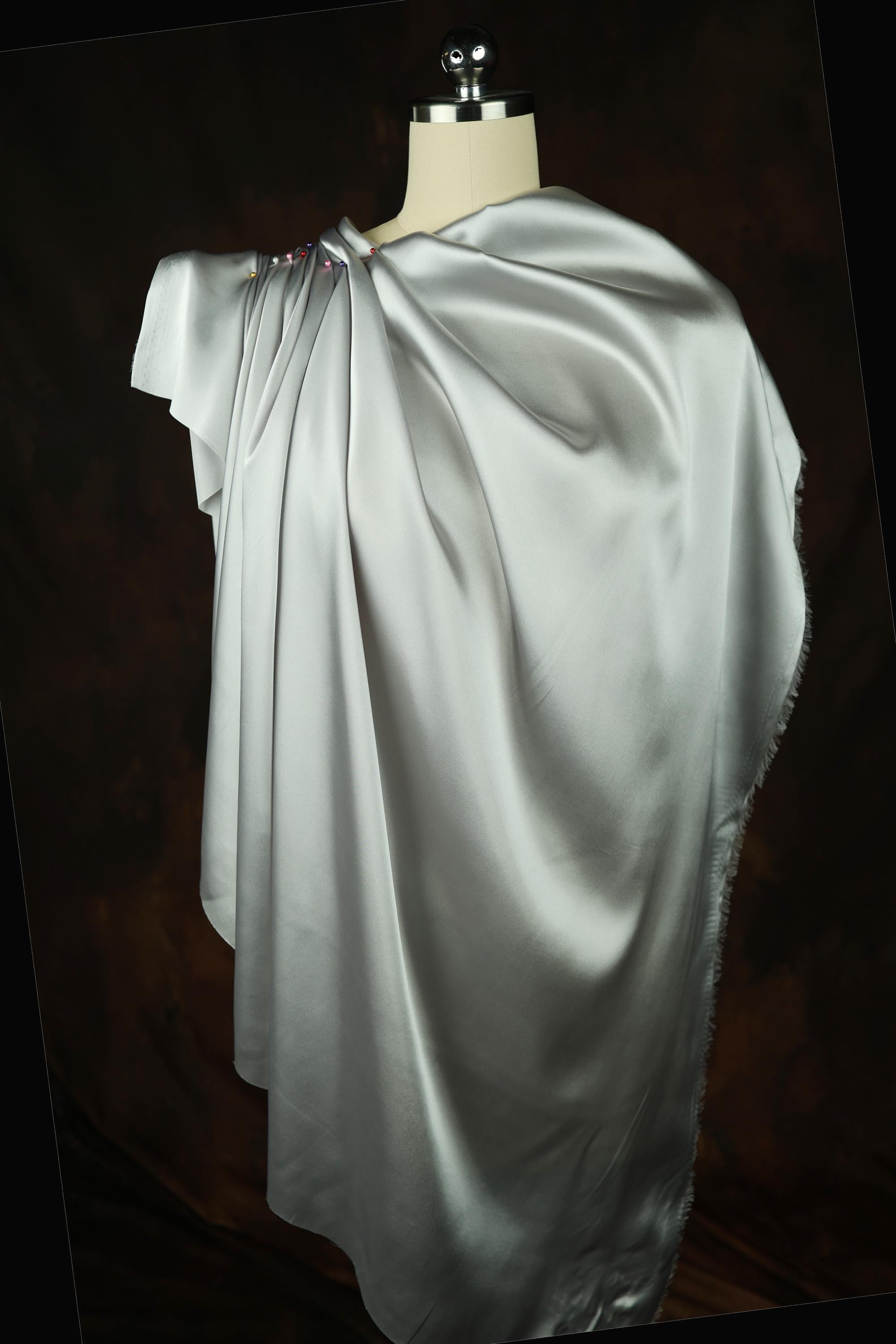 a mannequin dressed in a white dress with a cape