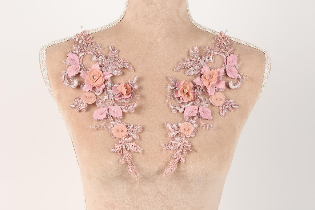 A mannequin torso with delicate pink floral embroidery on the shoulders.