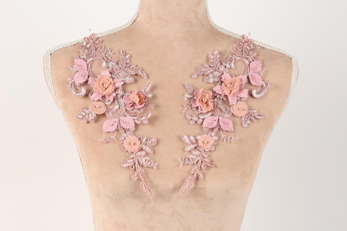 A mannequin torso with delicate pink floral embroidery on the shoulders.