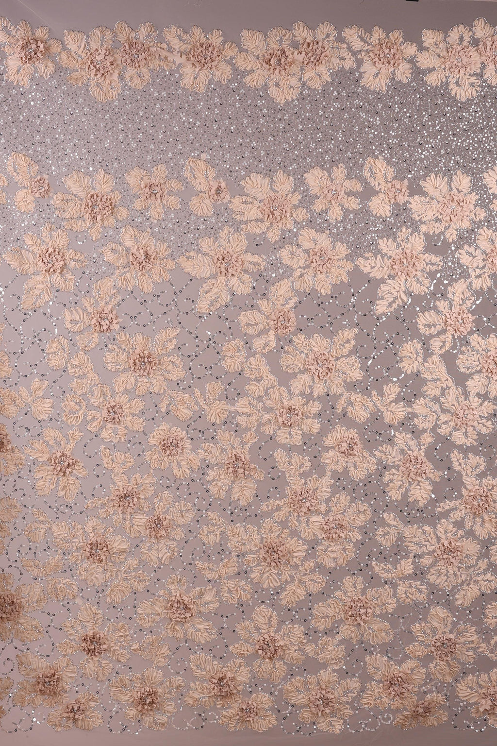 a close-up view of a fabric with a floral pattern. The fabric is adorned with numerous small, delicate flowers in shades of pink and white, creating a visually appealing and intricate design. The flowers are arranged in a repeating pattern across the fabric, adding a sense of depth and texture to the overall composition.