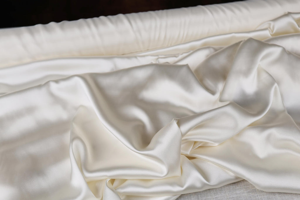 a close up of a bed with white sheets
