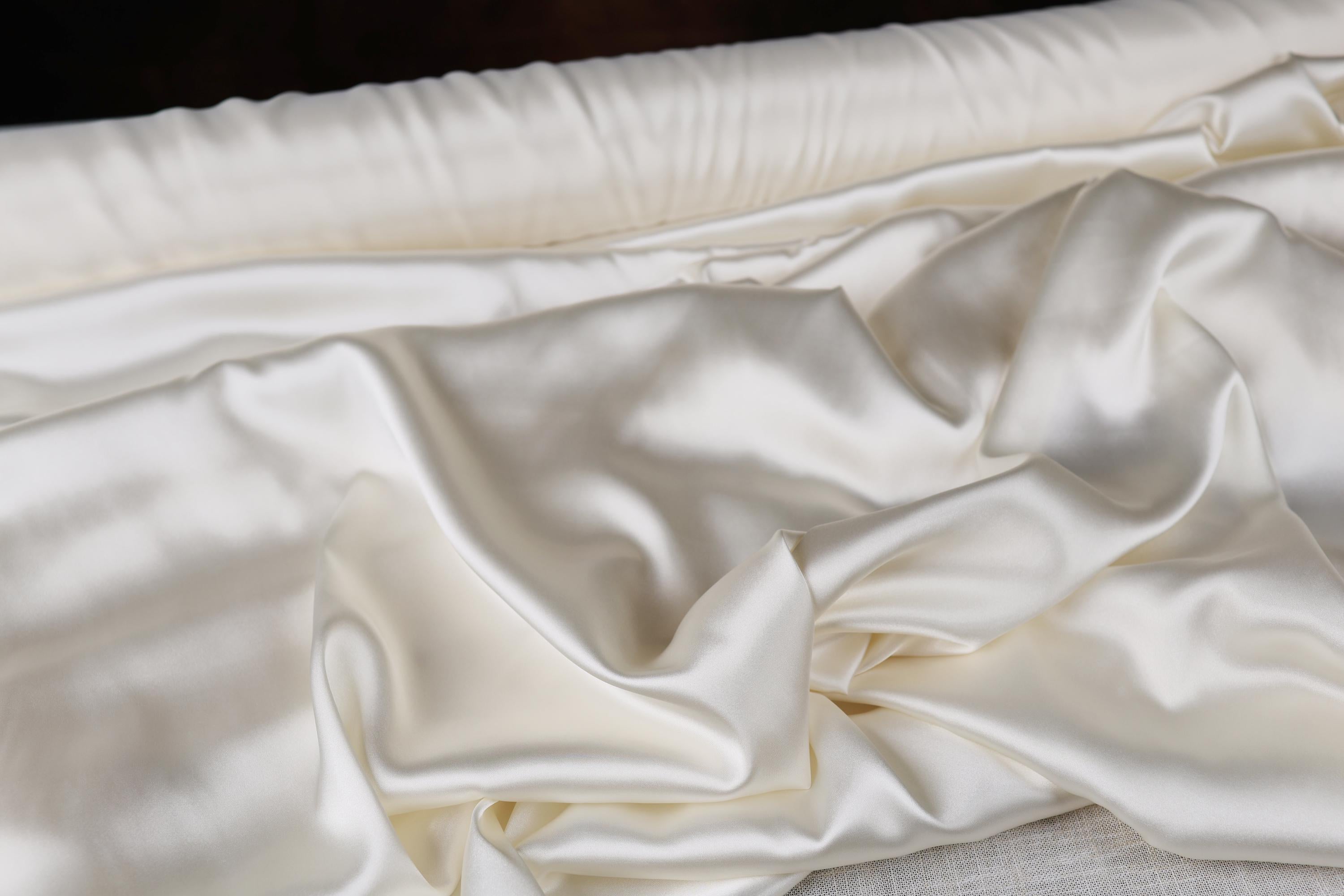 a close up of a bed with white sheets