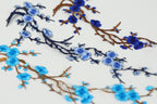 a close-up view of blue and brown branches with blue flowers, creating a visually appealing and intricate design.