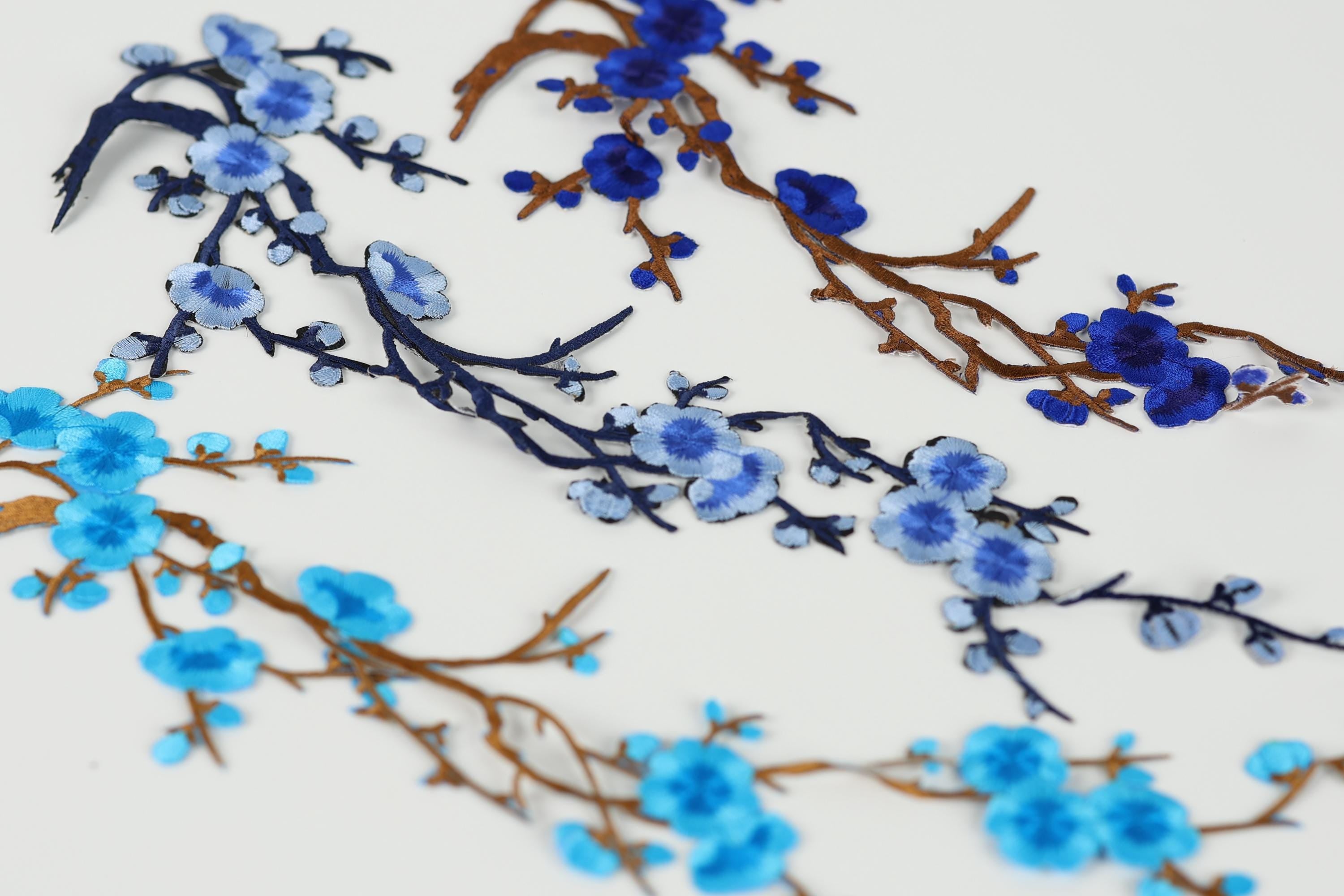 a close-up view of blue and brown branches with blue flowers, creating a visually appealing and intricate design.