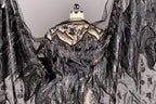 a black and silver dress with intricate beading and embroidery details, including a sheer back and flowing sleeves.