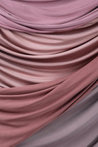 a close-up view of a fabric with a soft, flowing texture in shades of pink and purple. The fabric appears to be made of a soft, plush material, possibly cotton or silk, and is arranged in a way that creates a sense of movement and depth. The colors and texture of the fabric create a visually appealing and harmonious composition.