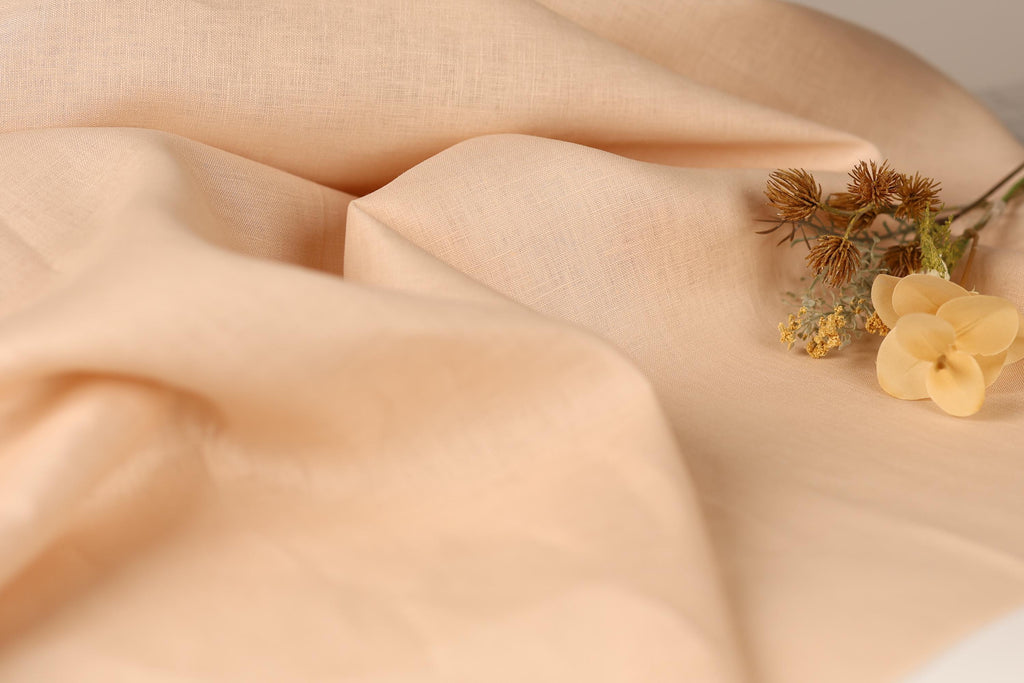 a close-up of a fabric with a delicate flower resting on it.