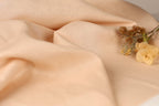 a close-up of a fabric with a delicate flower resting on it.