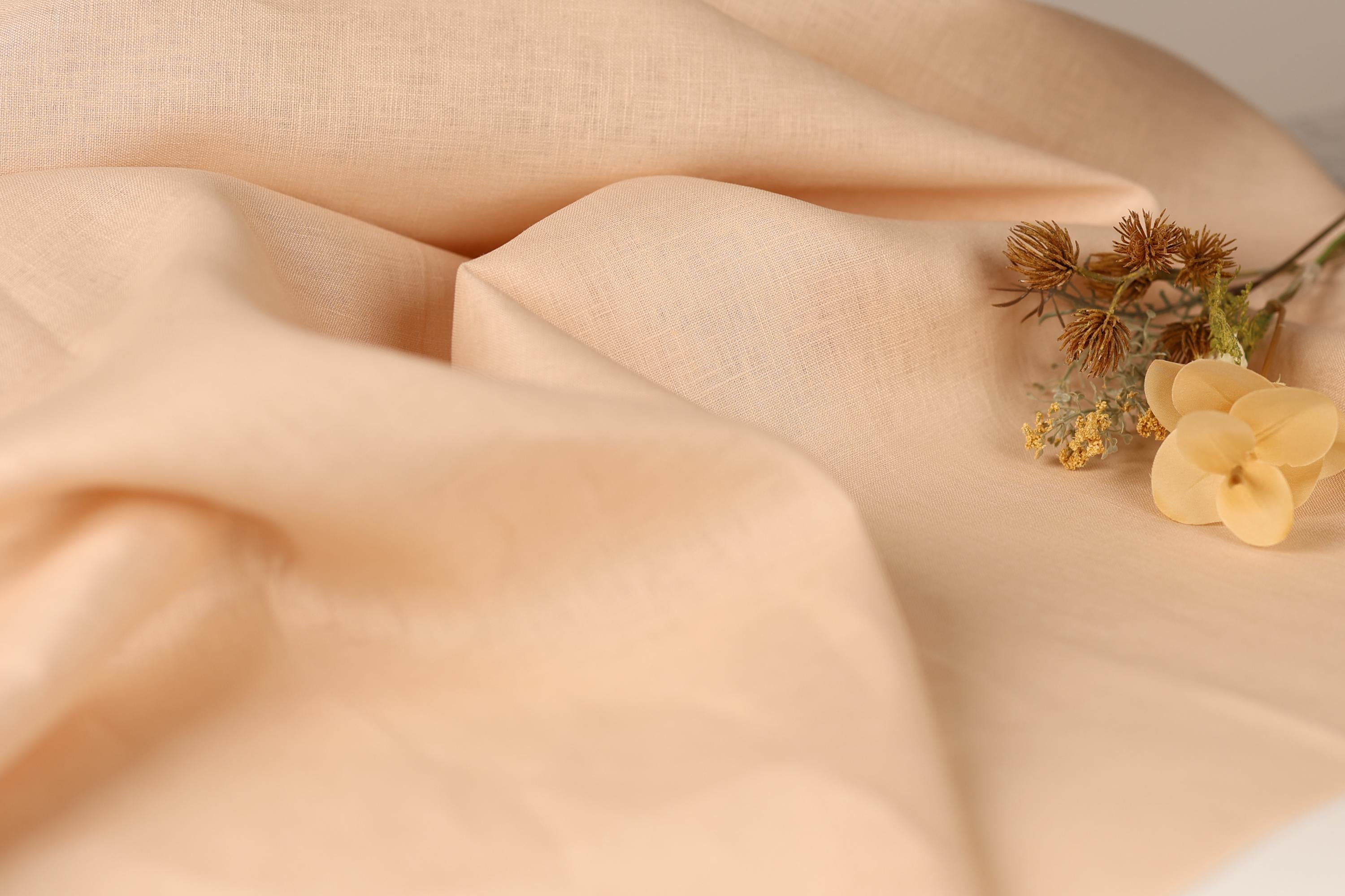 a close-up of a fabric with a delicate flower resting on it.