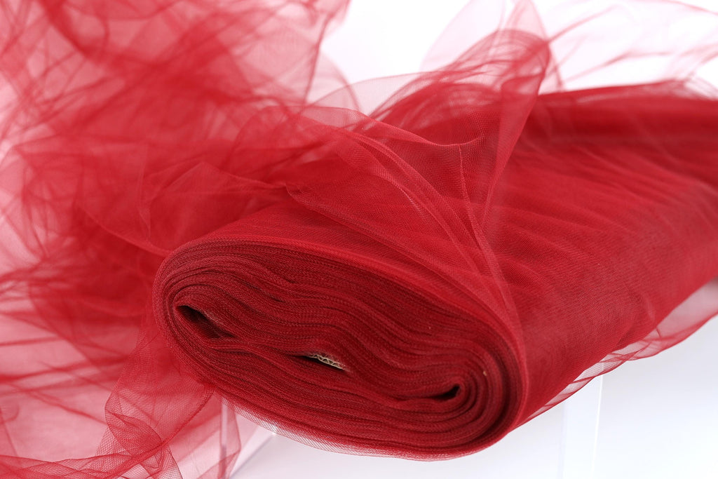 A close-up view of a red tulle fabric, with its smooth and flowing texture visible.