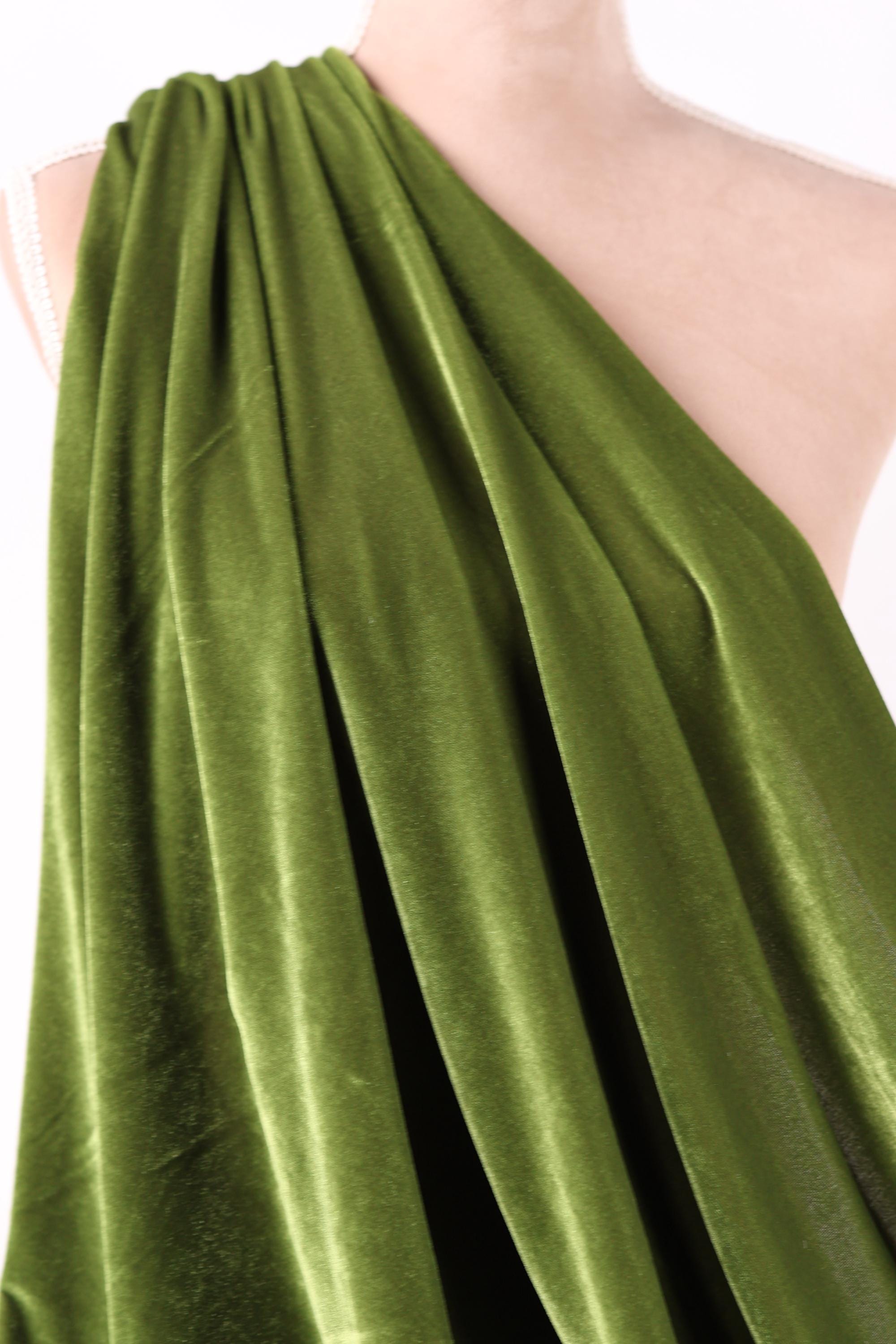 A close-up view of a green velvet fabric, with a smooth and shiny texture.