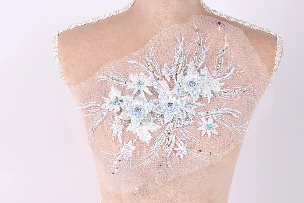 A mannequin with a delicate, intricate floral embroidery on its back.