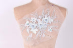 A mannequin with a delicate, intricate floral embroidery on its back.