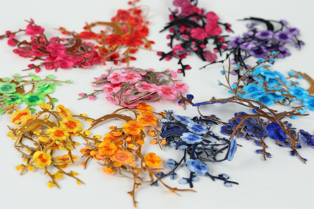 a variety of colorful flowers and branches, including red, pink, purple, blue, and yellow flowers, as well as green and orange branches, arranged in a visually appealing manner.