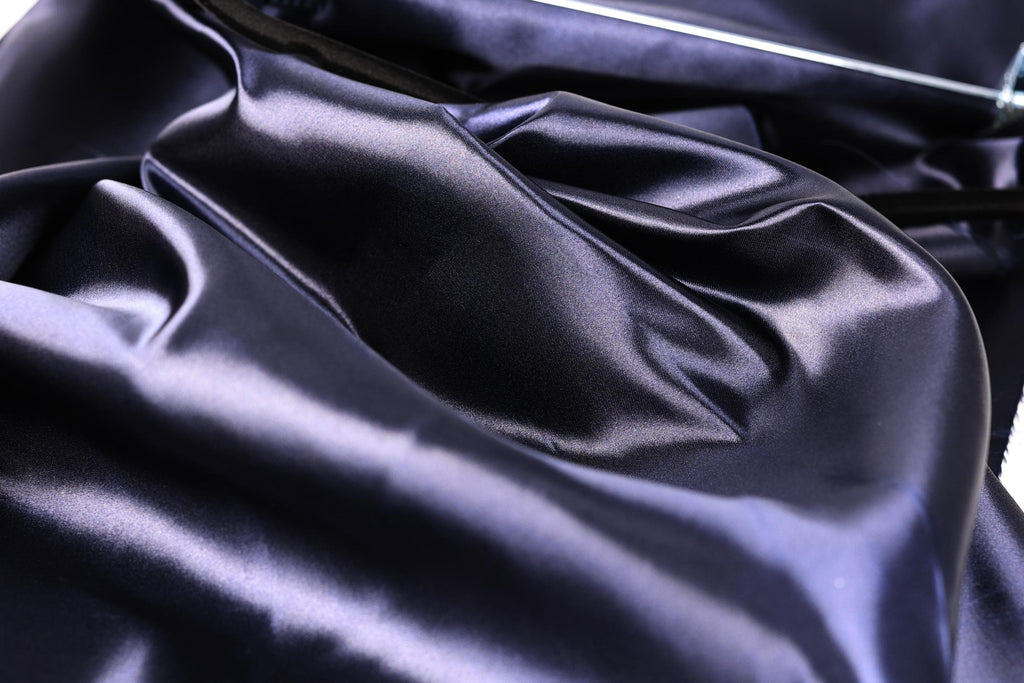 a close-up view of a shiny, dark blue satin fabric, with a slightly crumpled texture.