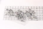 a clear ruler with a silver sequin flower design placed on it.