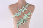 A mannequin torso with a green lace overlay, featuring intricate floral and leaf designs.