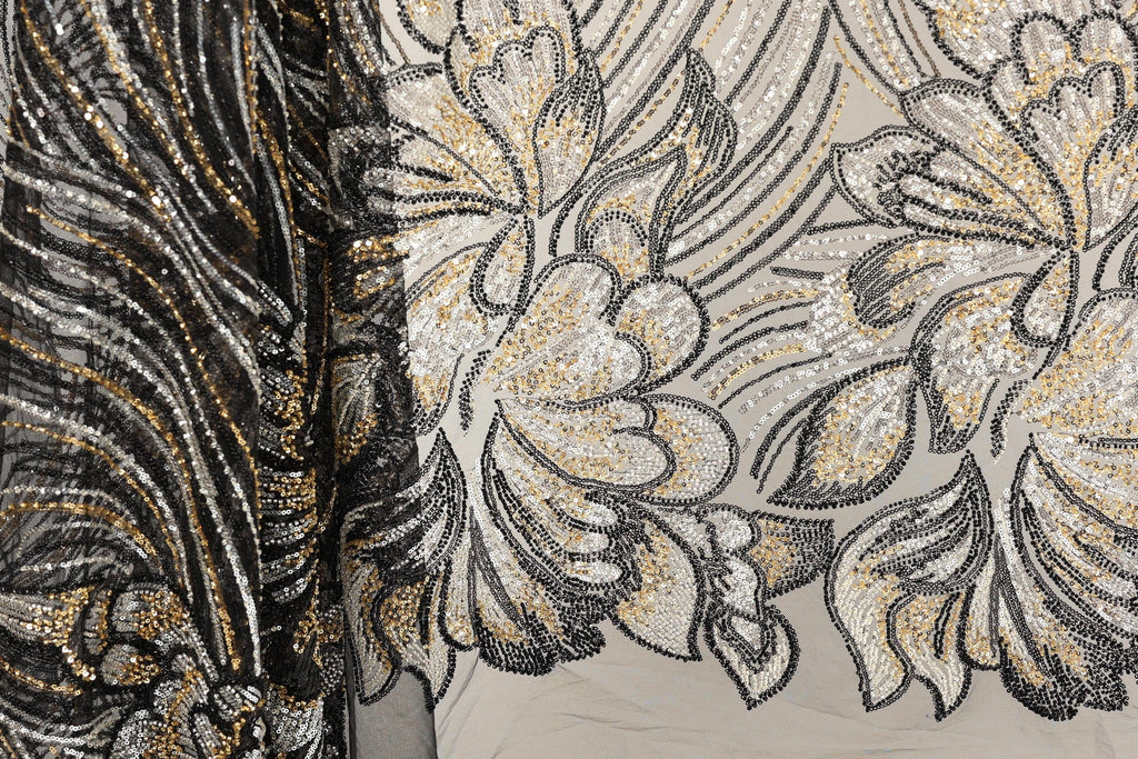 a close-up view of a fabric with a floral pattern, showcasing intricate details and a blend of black and gold colors.