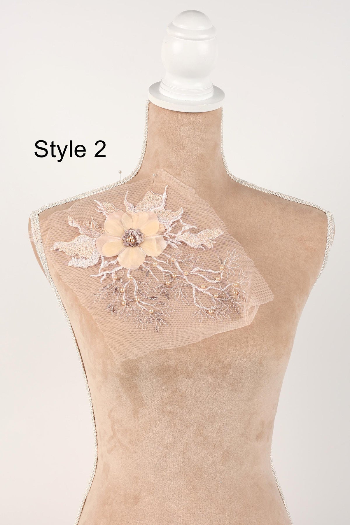 A mannequin with a decorative fabric piece on its chest, featuring a floral design.