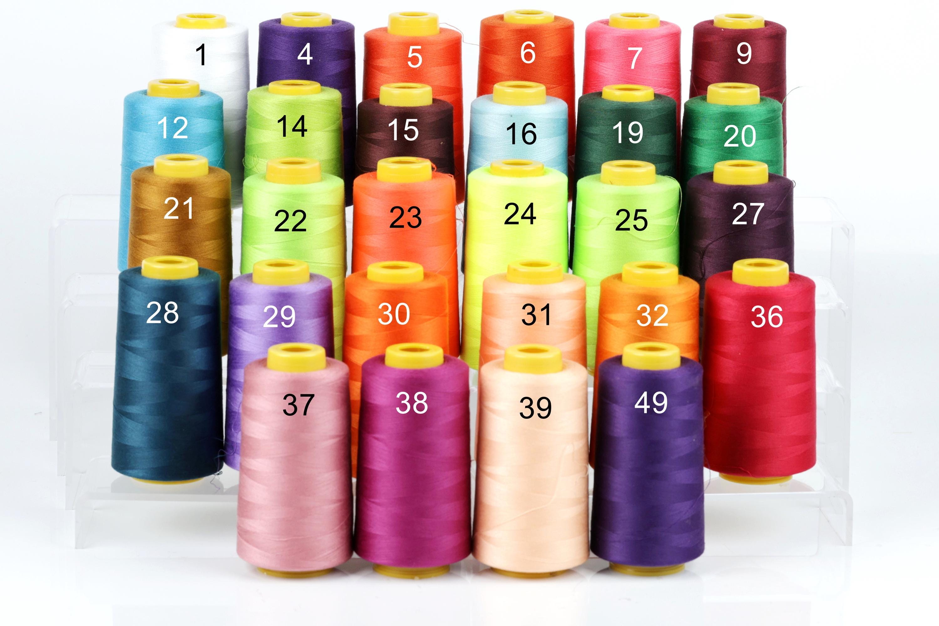 A collection of colorful spools of thread, each with a unique number, arranged in rows on a white background.