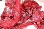 a close-up view of a red fabric with a floral pattern, featuring a mix of red and white colors.