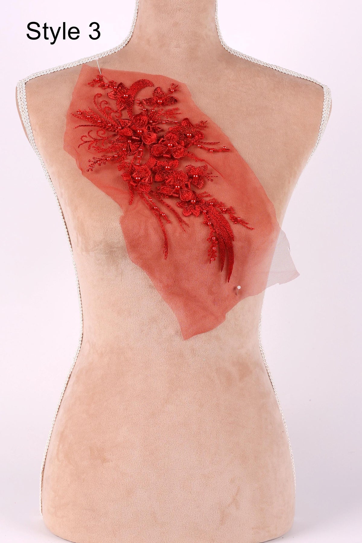 A mannequin with a red floral embroidered patch on its back.