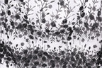 The image is a black and white collage featuring a repeating pattern of black flowers and leaves against a white background.