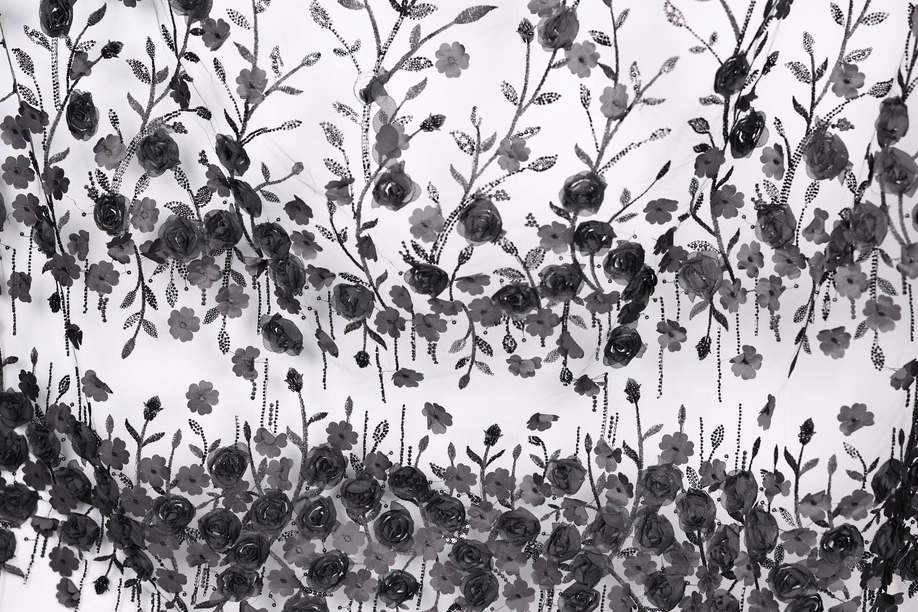 The image is a black and white collage featuring a repeating pattern of black flowers and leaves against a white background.