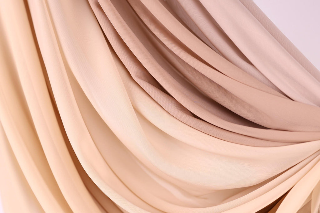 a close-up view of a fabric with a soft, flowing texture in shades of beige and brown.