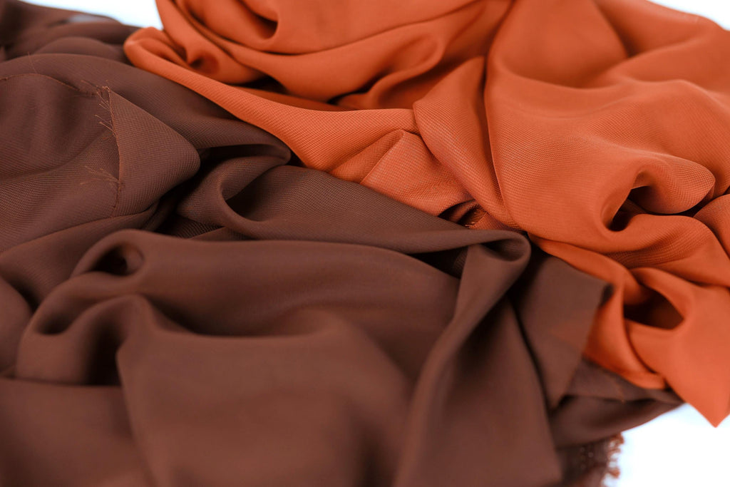 a close-up view of a crumpled fabric with a mix of brown and orange colors.