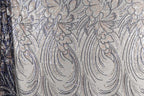 a close-up view of a fabric with a repeating pattern of silver and black lines, creating a visually striking and intricate design.