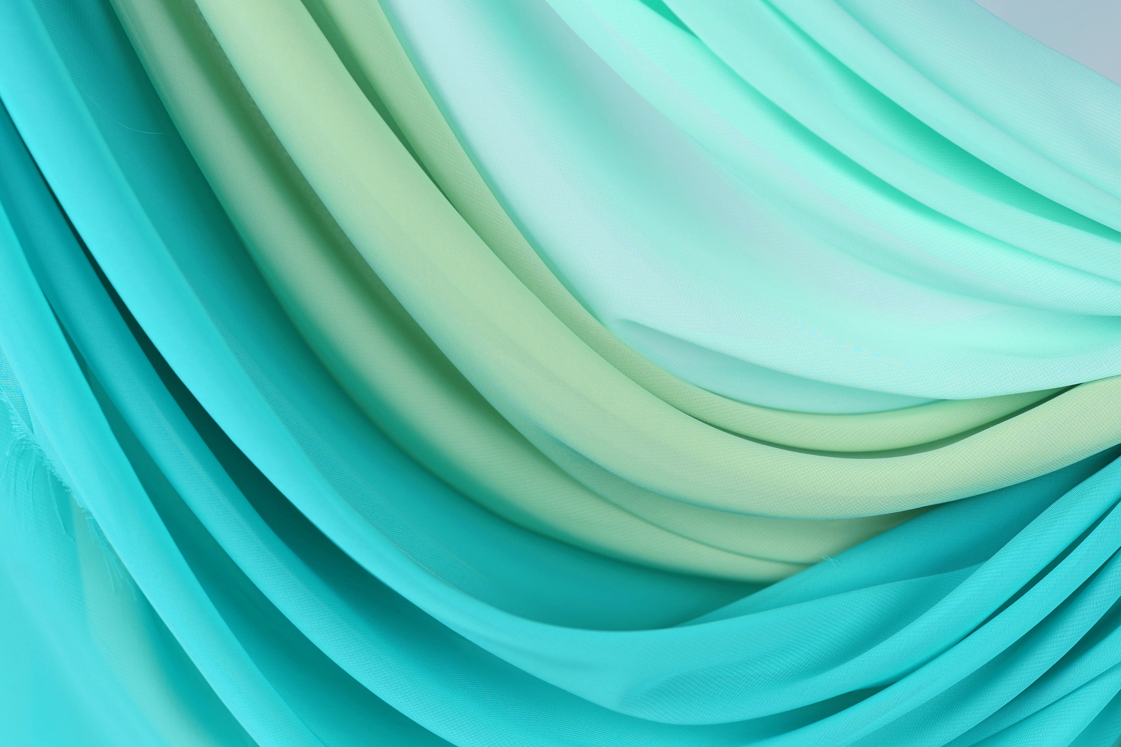 a close-up view of a fabric with a gradient of turquoise and mint colors, creating a visually appealing and textured appearance.