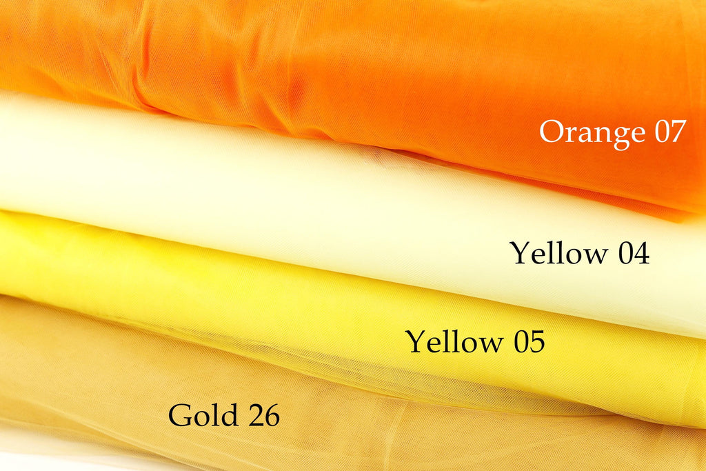 a stack of fabric swatches in various colors, including orange, yellow, and gold.