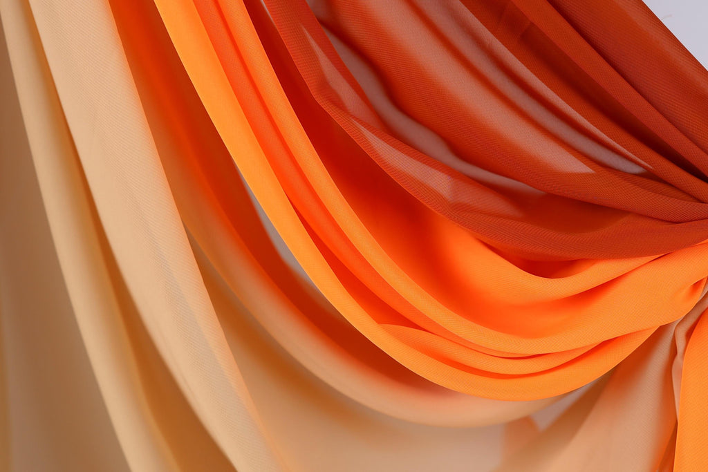a close-up view of a fabric with a gradient of orange and beige colors, creating a visually appealing and textured appearance.