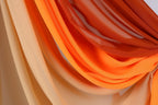 a close-up view of a fabric with a gradient of orange and beige colors, creating a visually appealing and textured appearance.